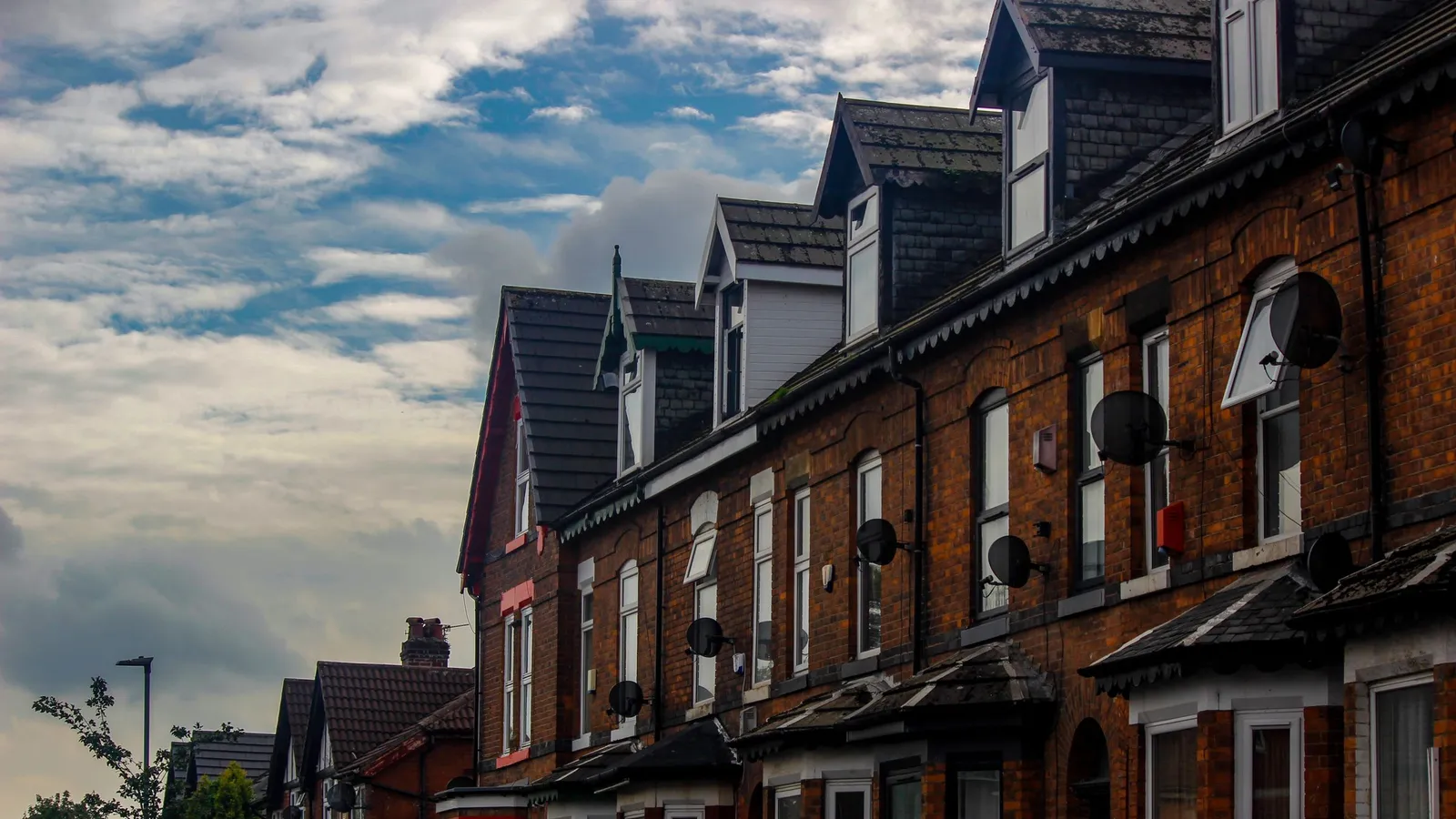 A street of red-brick terraced houses in an English town